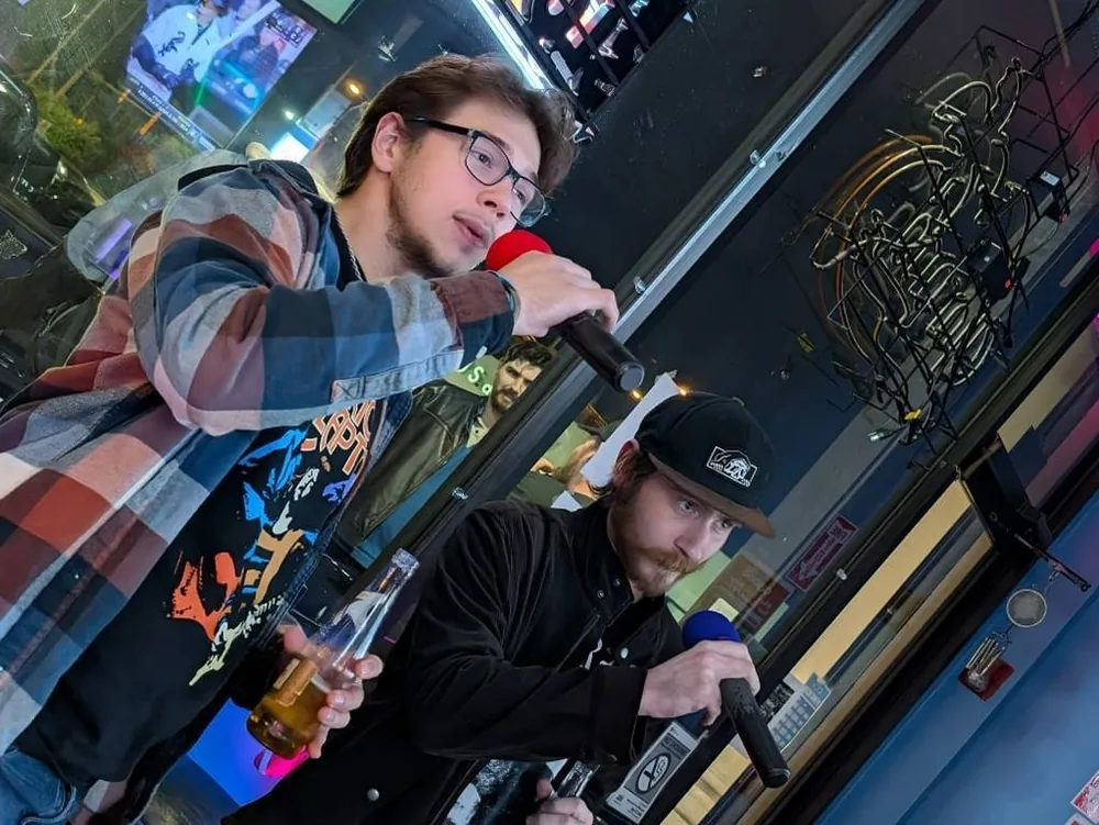 Two guests sharing microphones at Sam’s Bar and Gaming in Orland Hills